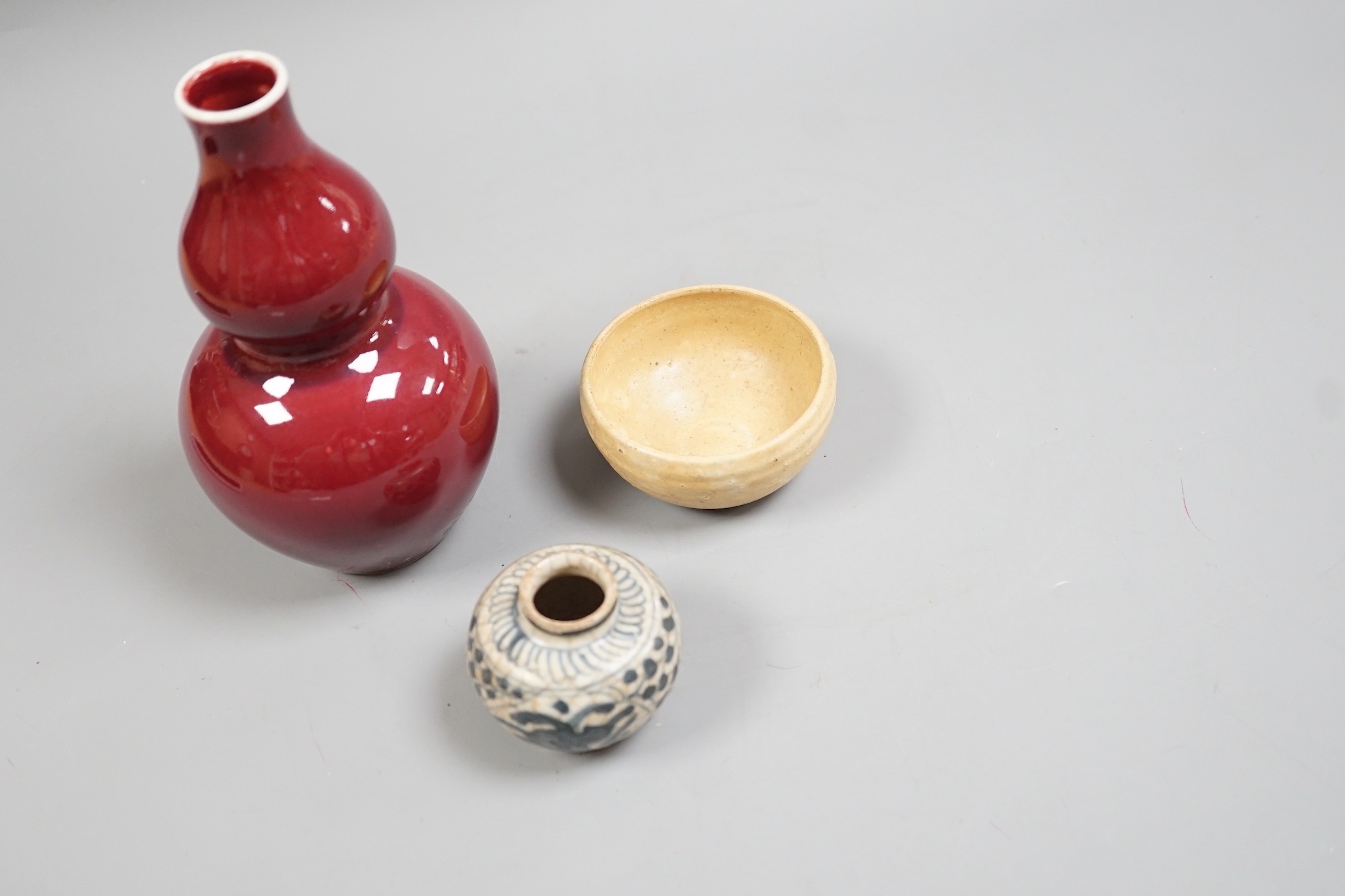 A Chinese sang de boeuf double gourd vase, a Swatow blue and white jarlet and a small cup, tallest 17cm